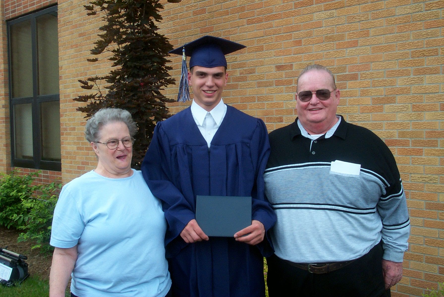 Adam with grandparents at graduation